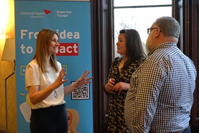 Three people in conversation at a Bright Red Triangle event