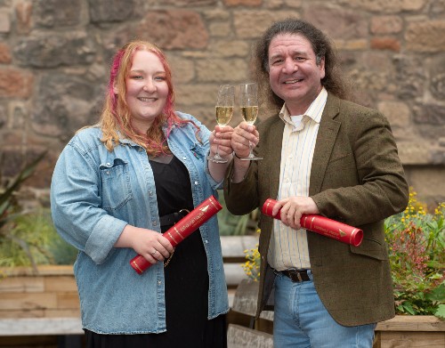 Jasmine and Adrian Smales with graduation scrolls and celebratory drink