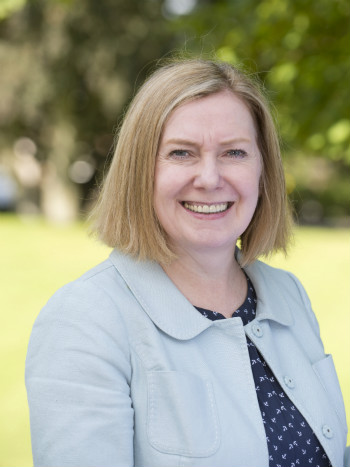 Head of shoulders portrait of Professor Anna Leask with tree in background