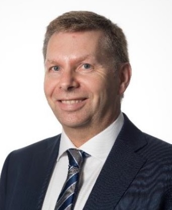 Head and shoulders of Bill Taylor wearing suit and tie