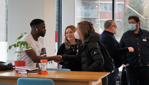 Five people mingling in the studio at the launch event