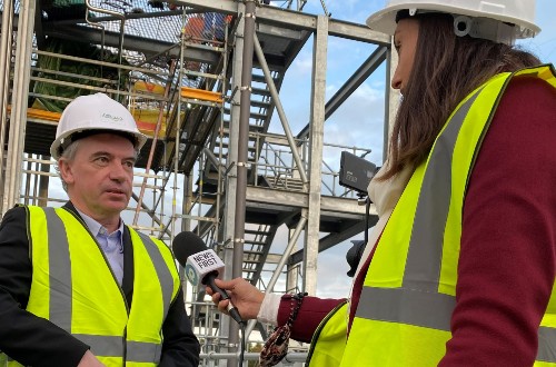 Martin Tangney, in hi-vis clothing, in close-up, being interviewed by female broadcast journalist