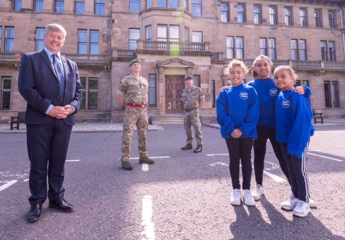 Suited politician, two uniformed soldiers and three uniformed school children in front of old military hospital at Craiglockhart