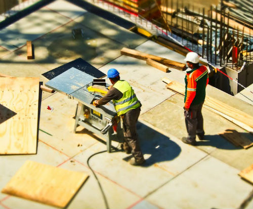 Picture from above and behind of two construction workers on site