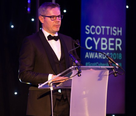 Derek MacKay at the lectern, speaking at the Scottish Cyber Awards 2018