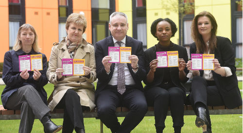 Five people sittng down in line with stickers, including Professor Andrea Nolan and minister Richard Lochhead
