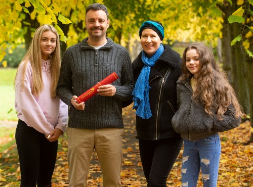 James Homan, 2020 Autumn graduate, with wife and two daughters in the grounds of Craiglockhart