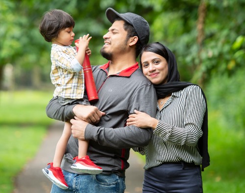 Jeshreena Palakkal in the park with husband, son and graduation scroll