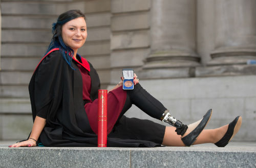 Kasey Johnson in graduation robes outside the Usher Hall