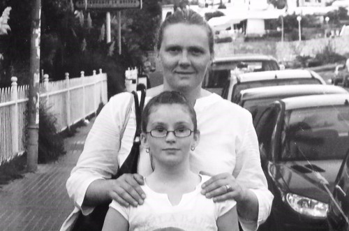 Mum Kirstie behind daughter Kayleigh Tidy with hands on her shoulders, taken when Kayleigh was a child