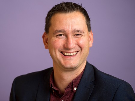 Head and shoulders of Miles Weaver wearing dark shirt and dark jacket