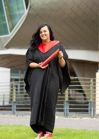 Natalie pictured outside the Egg at Craiglockhart with graduation scroll