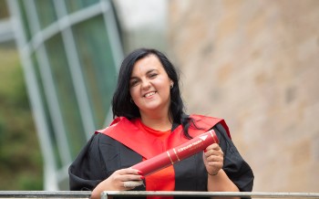 Natalie pictured outside the Egg at Craiglockhart with her graduation scroll