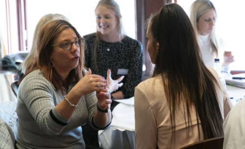 Two women in animated discussion at the SpeedSell event at the 2019 UK University Sales Competition 