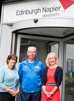 Three people posing outside of an entrance to Edinburgh Napier University