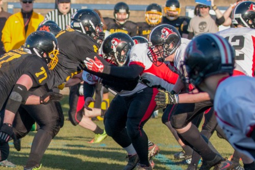 Close up action shot of opposing teams clashing in American Football match