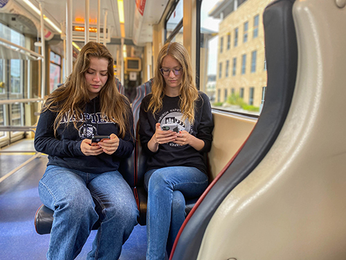 Students browse phones on an Edinburgh Tram