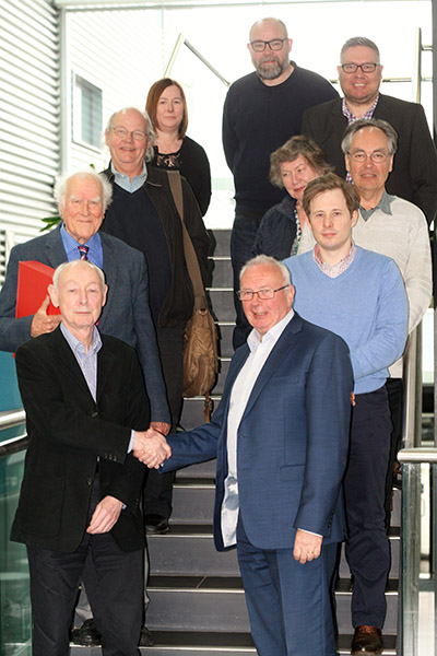 Group of people posing in front of the camera in the main staircase of Sighthill campus