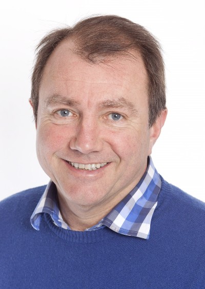 Head and shoulders of middle aged man in blue jersey