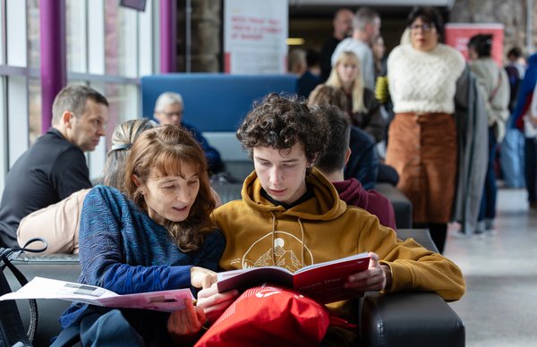 Parents and students sitting in Merchiston campus at Edinburgh Napier, discussing how they'll plan their open day. 