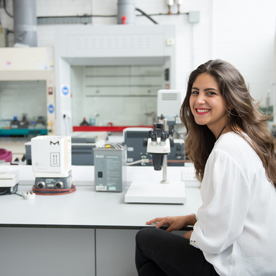 Andrea in a lab smiling for the camera