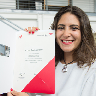 Andrea smiling with her degree certificate
