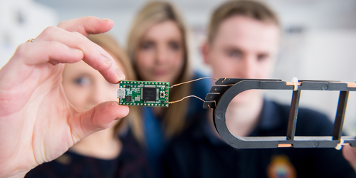 Students holding a computing chip.
