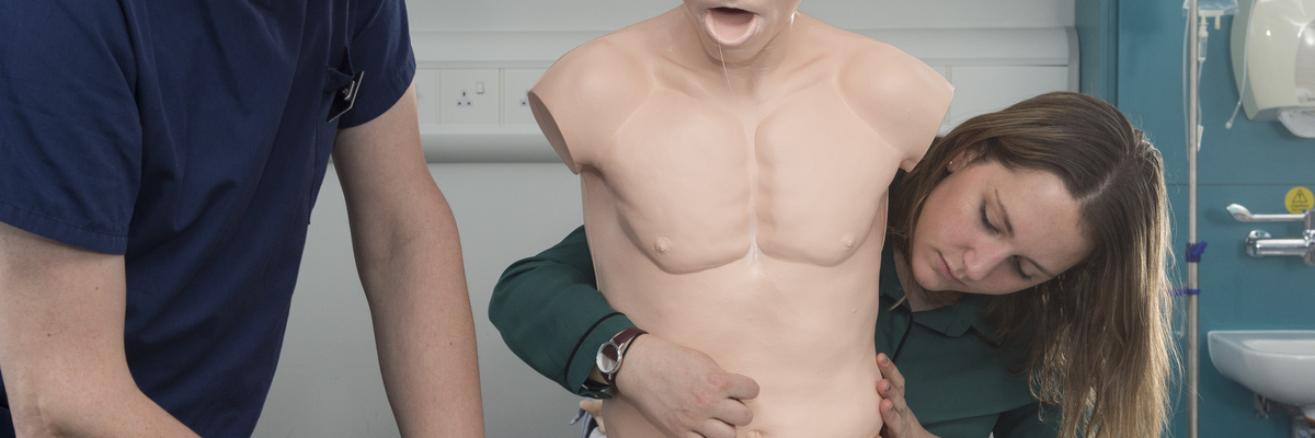 Physiotherapy students practicing on a dummy. 