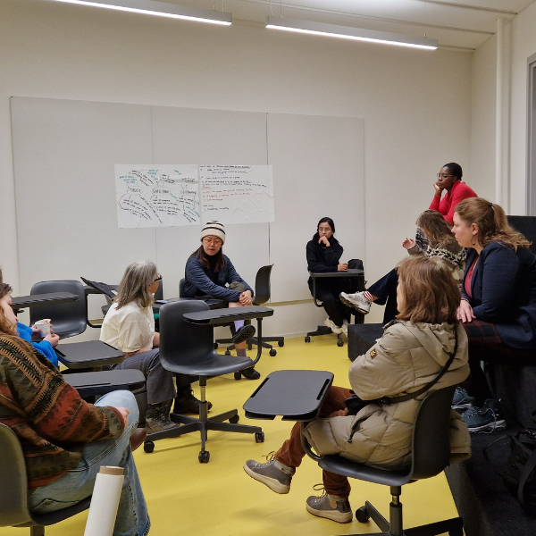 Group discussion in a classroom with students seated in a circle.