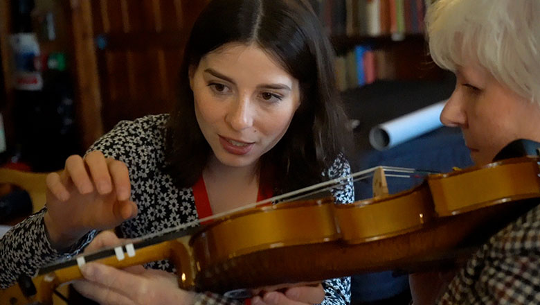 As part of Community Instrumental Music Service for Rural Scotland, PHD student Arianna helps an adult learner play the violin