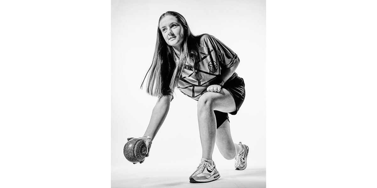 Beth Riva, lawn bowls world champion and law student, rolls her bowl 