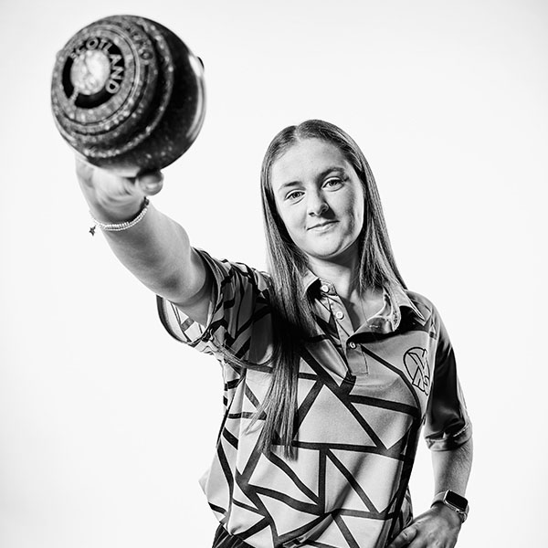 Beth Riva, lawn bowls world champion and law student, holds her bowl and smiles confidently at the camera