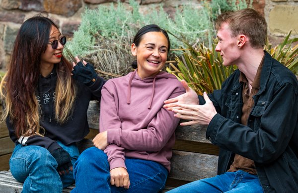 A photo showcasing a group of Edinburgh Napier students chatting outside after lectures in the courtyard of Merchiston campus. 