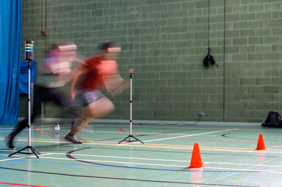 Two coaching students running in the gym hall.