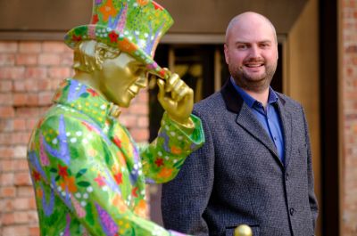 Image of Alan McGarrie standing beside a Johnnie Walker Striding Man statue