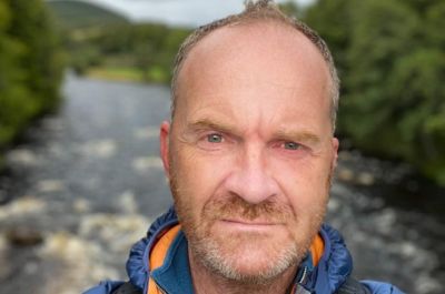 Selfie image of Andy Last with a river and trees behind him