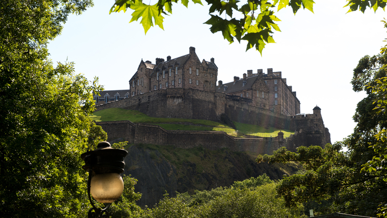 Edinburgh Castle surrounded by trees, taken from Princes Street gardens below.